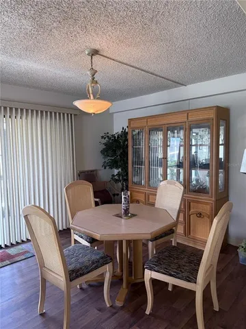 a dining room with furniture a chandelier and wooden floor
