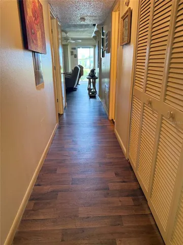 a hallway with wooden floor and stairs