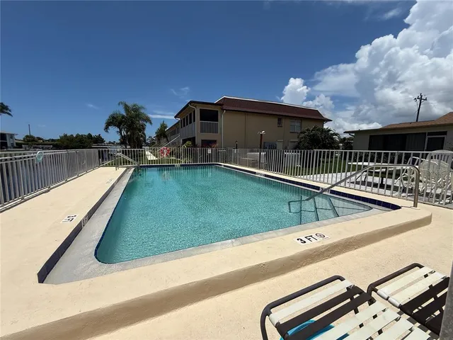 a view of a swimming pool with a chair and tables