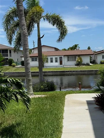 a front view of a house with a yard and potted plants