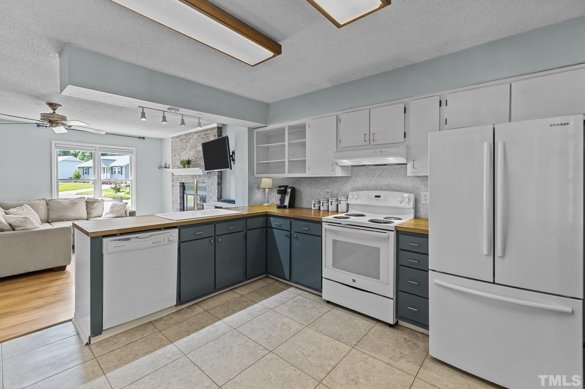 208 Longneedle Court Raleigh, NC 27603 - Photo 7 of 24 a kitchen with granite countertop appliances and white cabinets