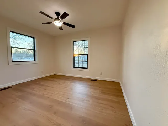 a view of empty room with wooden floor