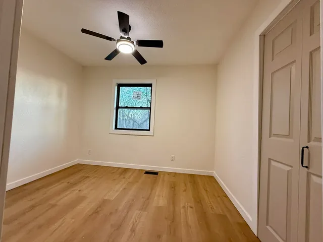 a view of empty room with wooden floor