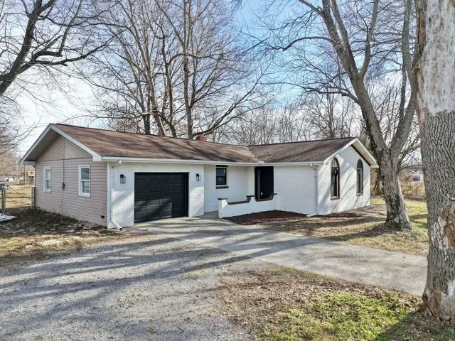 a view of house with yard and large tree