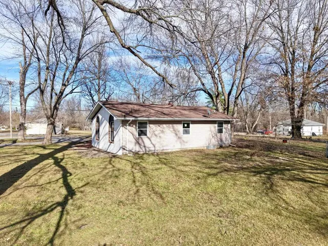 a white house that has tree in front of it