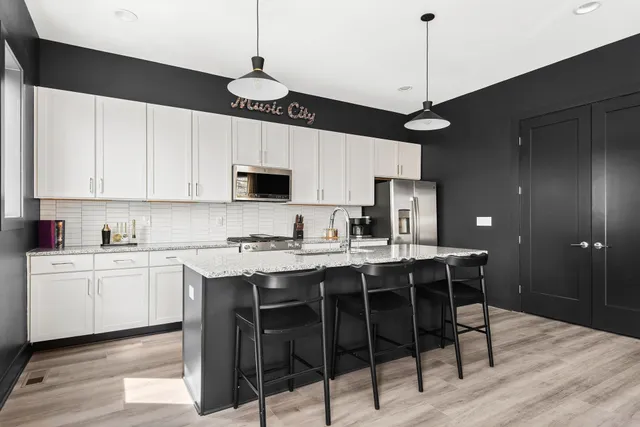 a kitchen with stainless steel appliances granite countertop a sink stove and refrigerator