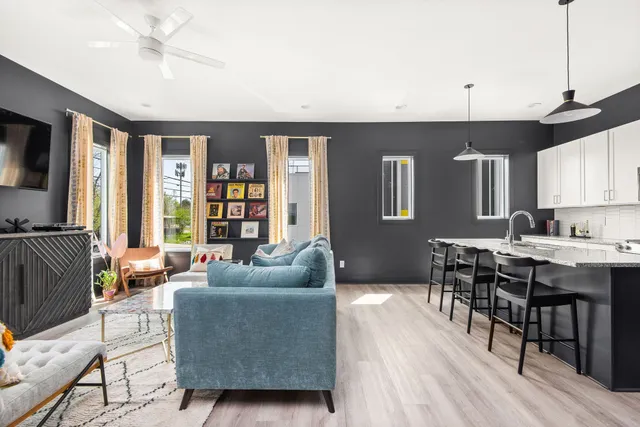 a living room with furniture kitchen view and a window