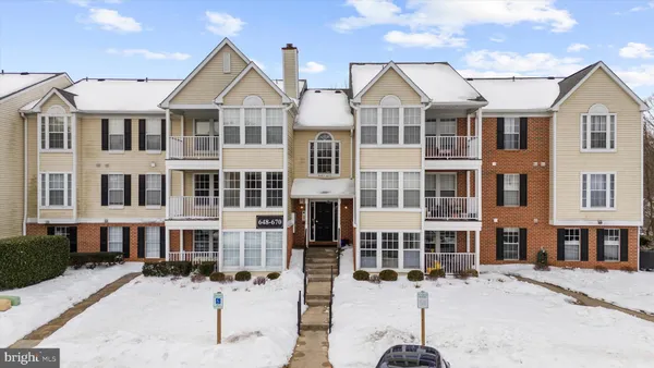 a view of a large white building next to a road