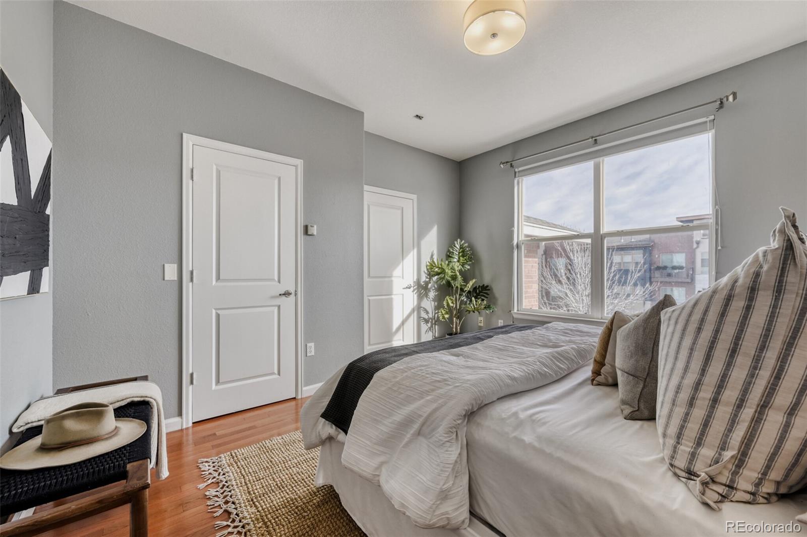 85 Uinta Way, Unit 106 Denver, CO 80230 - Photo 18 of 42 a bedroom with a bed and potted plant next to a window