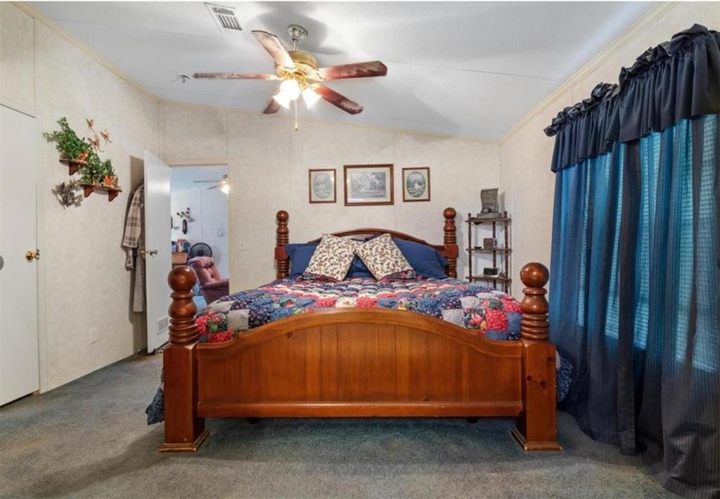 7141 County Road 1050 Celeste, TX 75423 - Photo 19 of 32 a bedroom with a bed and a chandelier