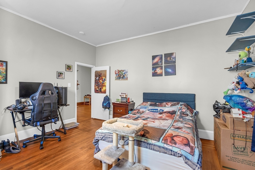 276 Pine Street Lowell, MA 01851 - Photo 19 of 42 a bedroom with a bed and wooden floor