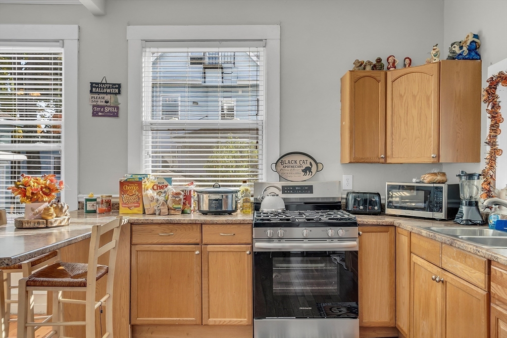 276 Pine Street Lowell, MA 01851 - Photo 10 of 42 a kitchen with stainless steel appliances granite countertop a stove a sink and a microwave