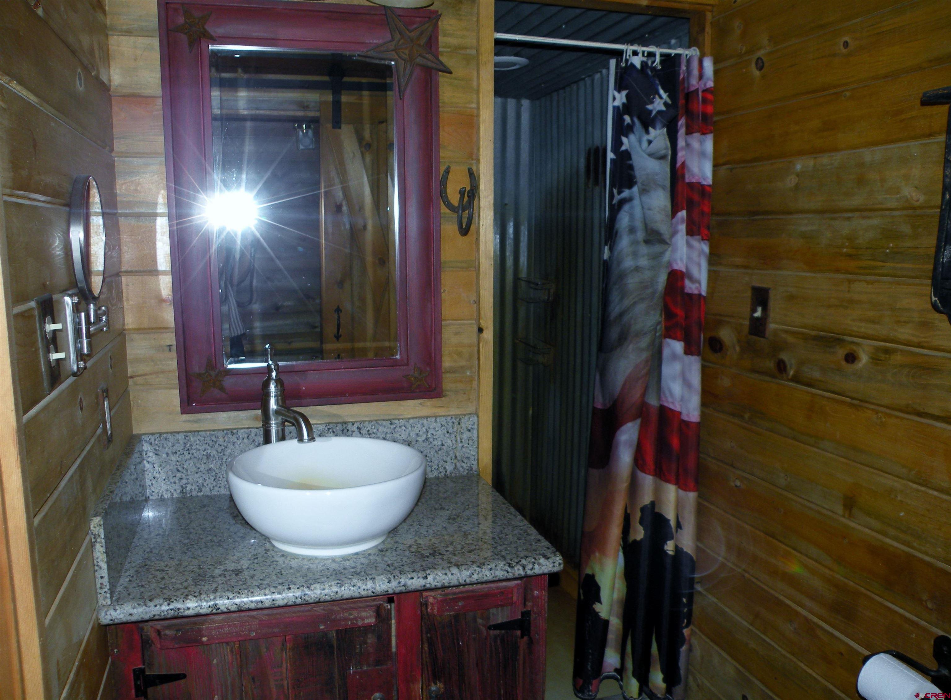 27793 BB Road Nucla, CO 81424 - Photo 13 of 18 a bathroom with a granite countertop sink and a mirror