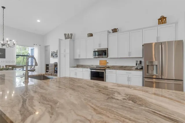 a kitchen with stainless steel appliances granite countertop a refrigerator microwave and wooden floor