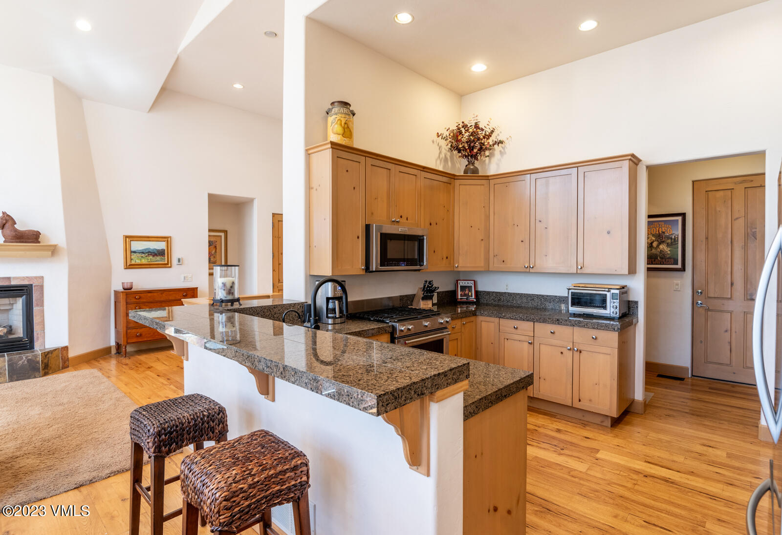 306 Hackamore Road, Unit A Edwards, CO 81632 - Photo 11 of 27 a kitchen with stainless steel appliances granite countertop a stove top oven a sink dishwasher a dining table and chairs with wooden floor