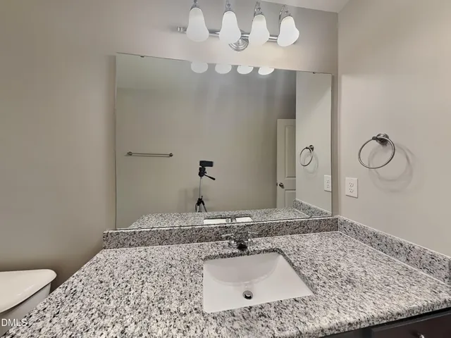 a bathroom with a sink a toilet and a mirror