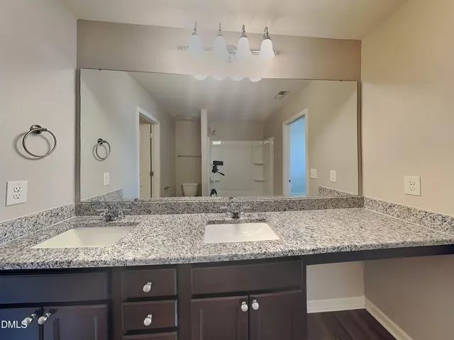 a bathroom with a granite countertop sink and a mirror