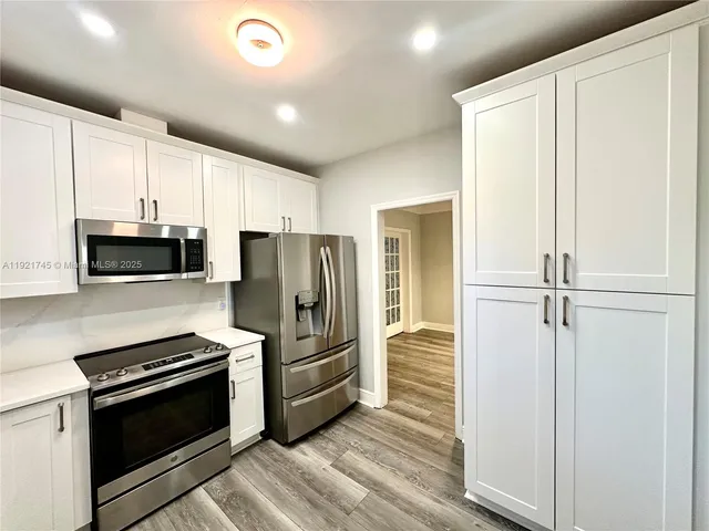 a kitchen with stainless steel appliances a refrigerator stove and microwave