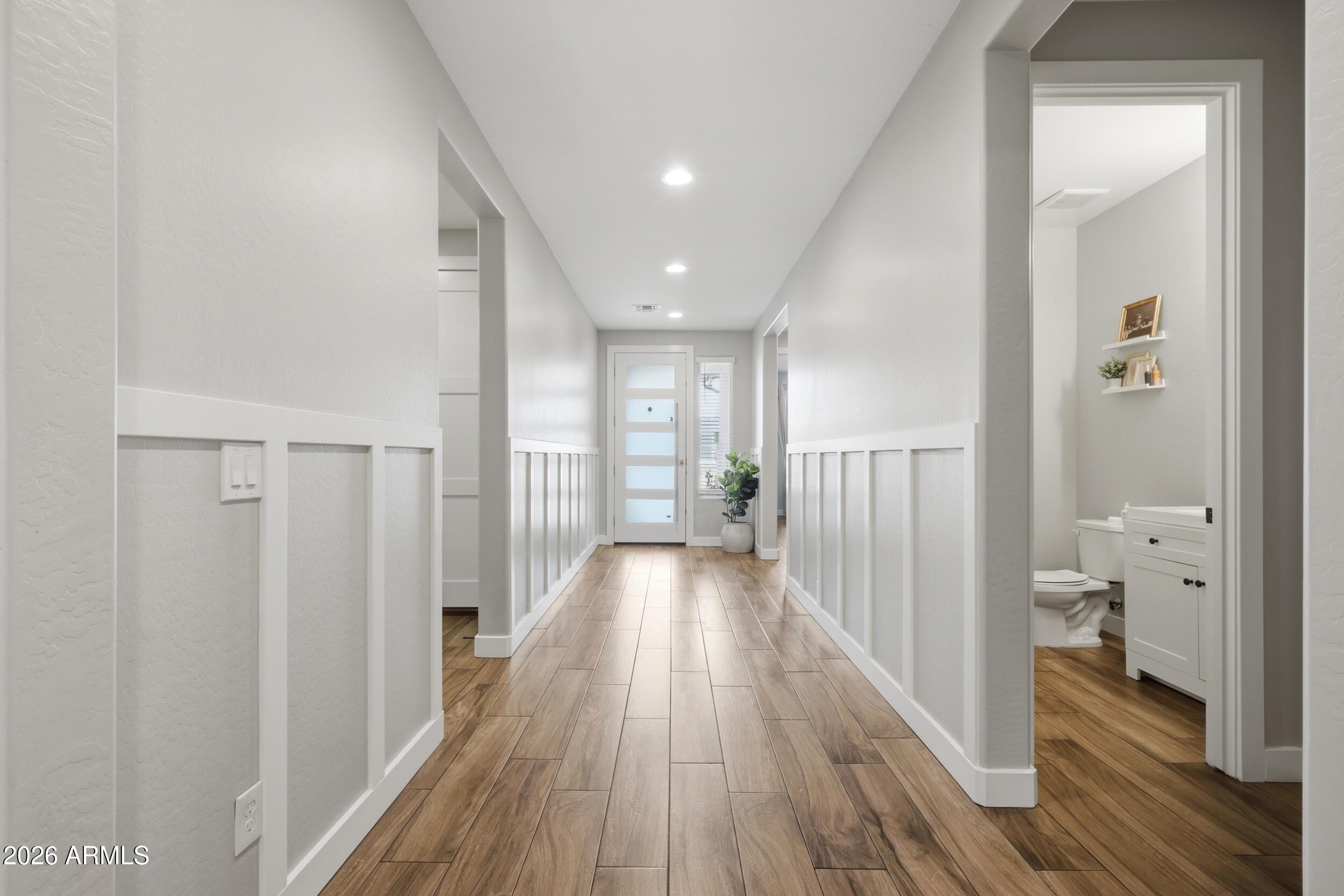 12517 West Lawrence Road Glendale, AZ 85307 - Photo 9 of 52 a view of a hallway with wooden floor and a bathroom
