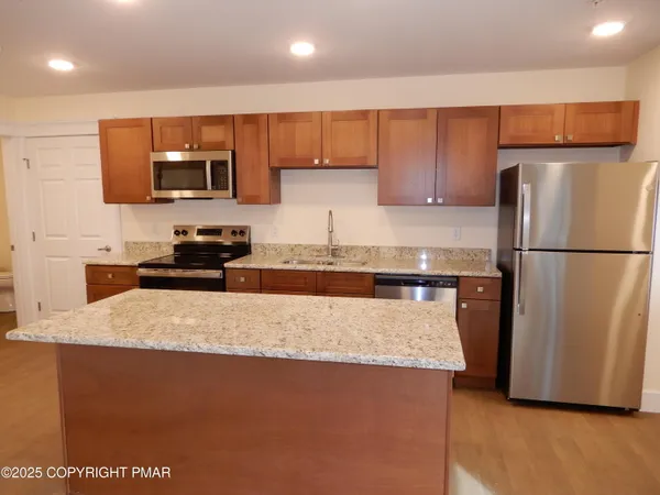 a kitchen with stainless steel appliances granite countertop a sink stove and refrigerator