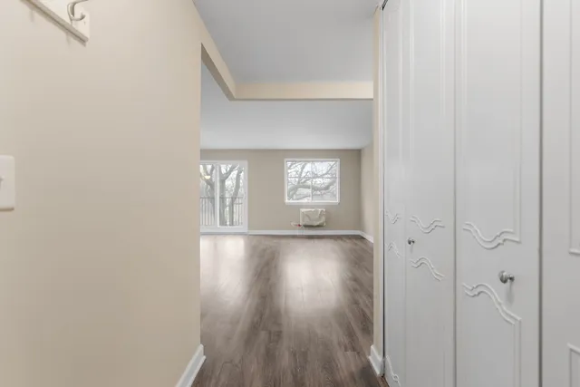 a view of empty room with window and wooden floor