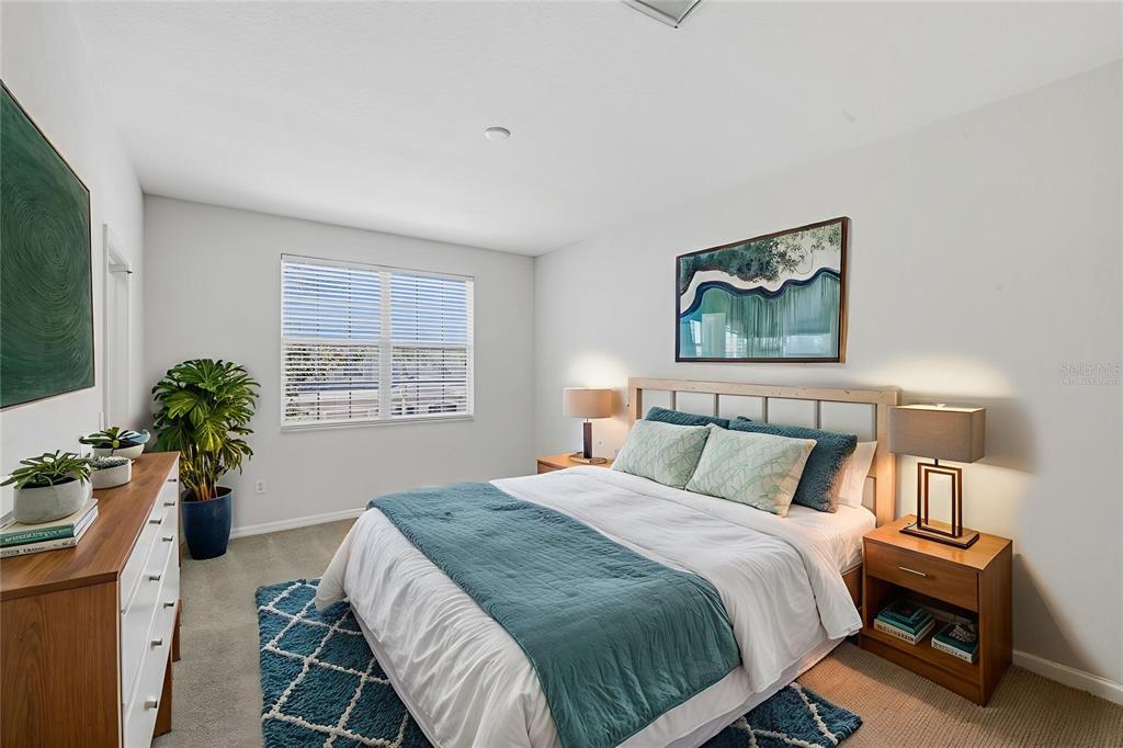 3914 Silverlake Way Wesley Chapel, FL 33544 - Photo 16 of 38 a bed sitting in a bedroom next to a window with potted plant