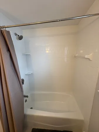 a bathroom with a shower and a bath tub