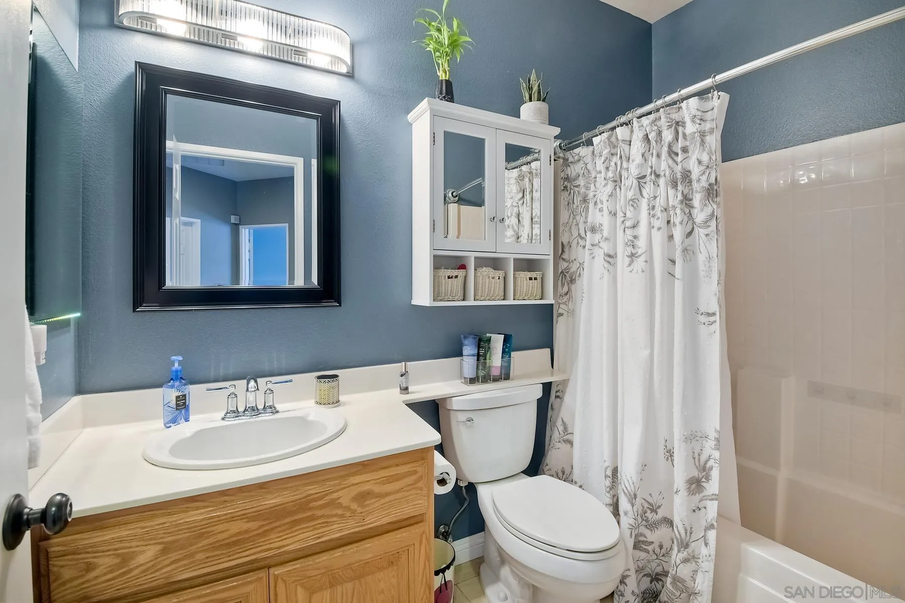 1145 Monterey Place Encinitas, CA 92024 - Photo 22 of 34 a bathroom with a sink a toilet a mirror and shower curtain