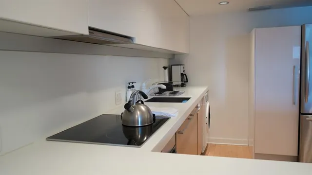 a kitchen with stainless steel appliances granite countertop a sink a stove a refrigerator and cabinets