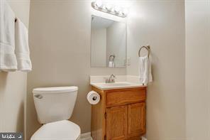 14727 McKnew Road Burtonsville, MD 20866 - Photo 18 of 20 a bathroom with a granite countertop toilet sink and mirror