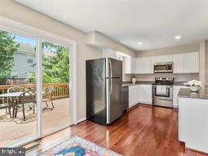 14727 McKnew Road Burtonsville, MD 20866 - Photo 4 of 20 a kitchen with granite countertop a refrigerator a stove a sink a dining table and chairs with wooden floor