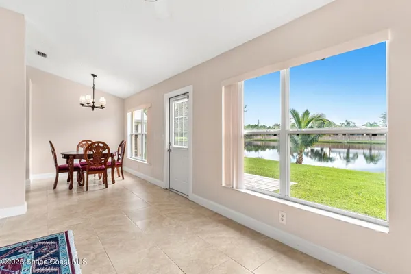 a dining room with furniture and a floor to ceiling window