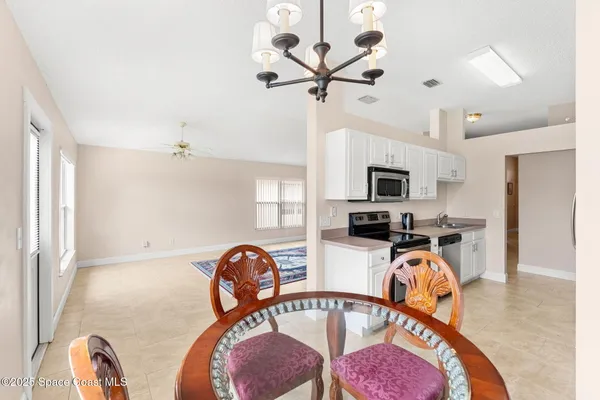 a view of a livingroom with furniture a fireplace a rug and a chandelier