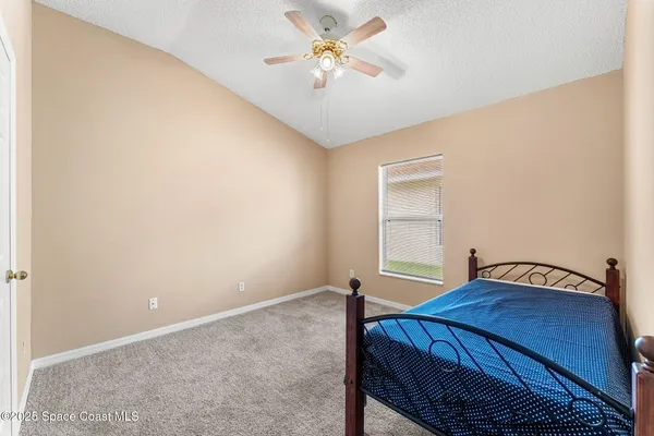 a bedroom with a bed and a chandelier fan