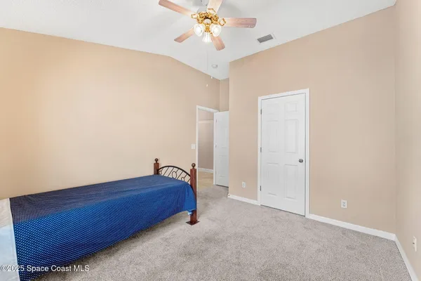 a bedroom with a bed and a ceiling fan