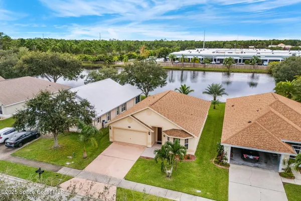an aerial view of a house with a garden and lake view