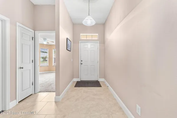 a view of a hallway with wooden floor and windows