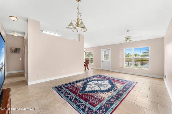an entryway with a chandelier and a rug