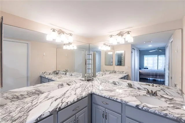 a bathroom with a granite countertop double vanity sink and a large mirror