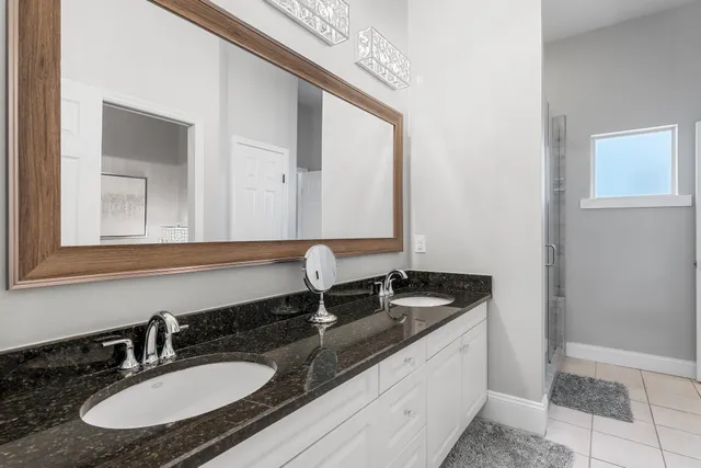 a bathroom with a granite countertop sink and a mirror