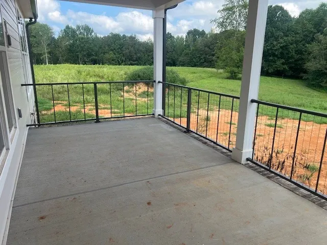 a view of an empty room with wooden floor fireplace and a window