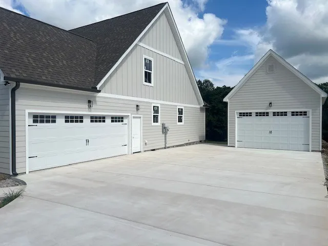 a view of white house with yard and a garage