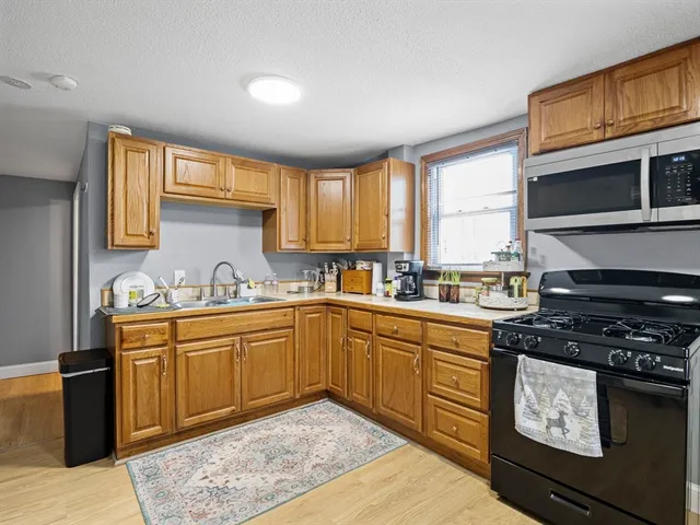 a kitchen with stainless steel appliances granite countertop a stove a sink and a microwave