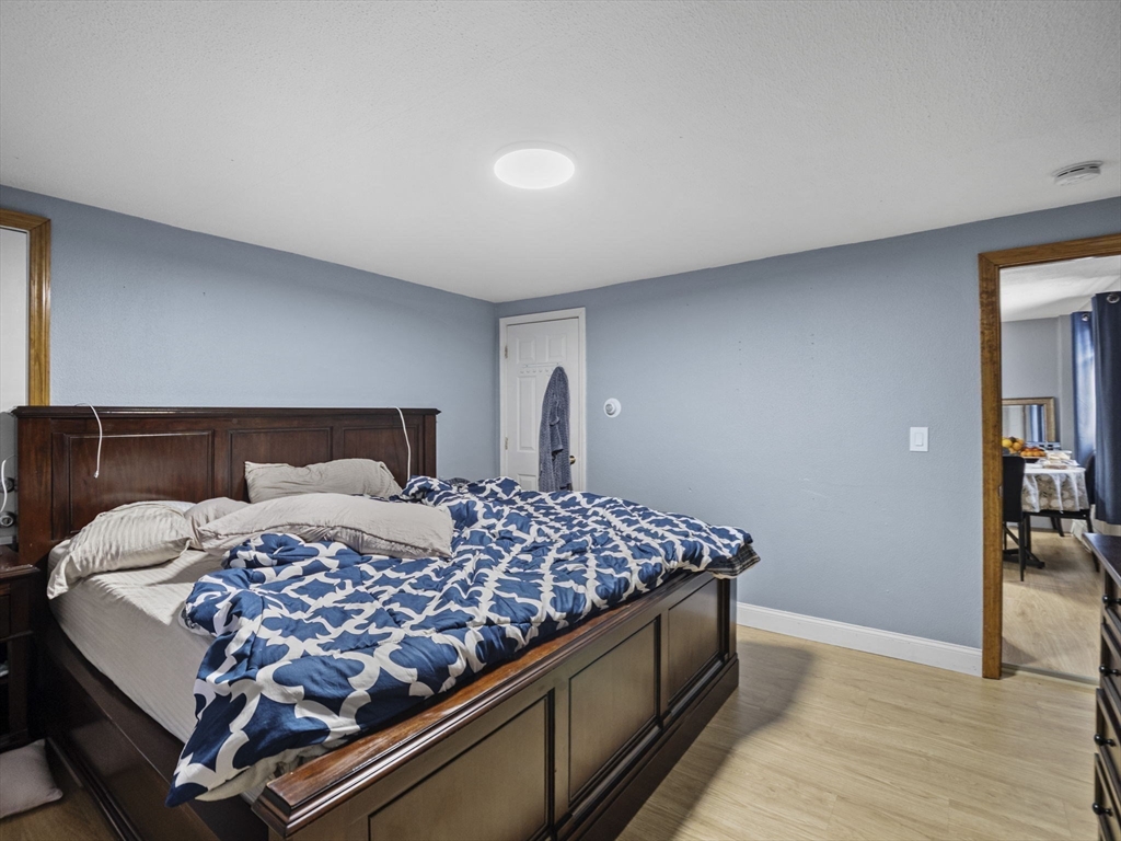 8 Clarks Court Lowell, MA 01852 - Photo 17 of 33 a bedroom with a bed and wooden floor