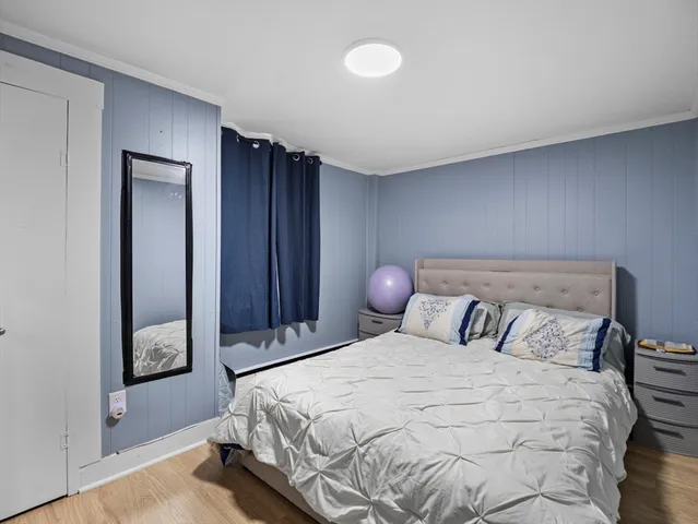 a bedroom with a bed and painting on the wall