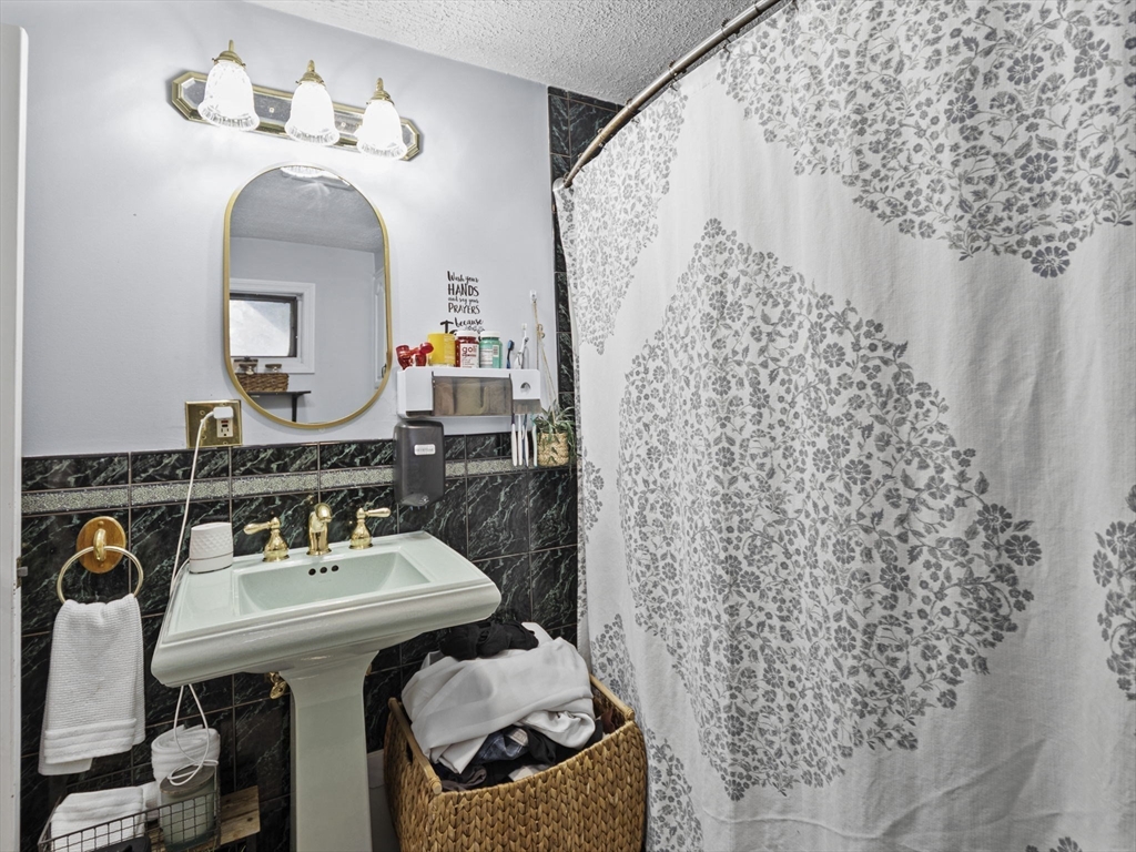 8 Clarks Court Lowell, MA 01852 - Photo 20 of 33 a bathroom with a sink a mirror and a toilet
