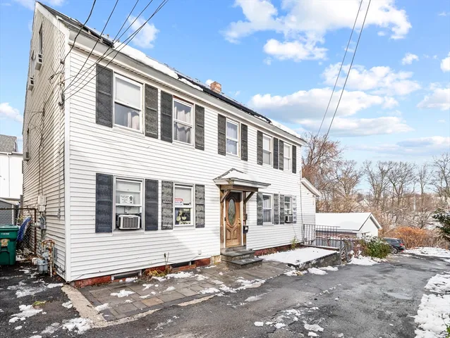 a front view of a house with a tree