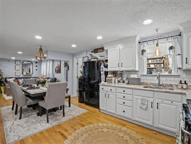 a large kitchen with kitchen island a dining table chairs stainless steel appliances and cabinets