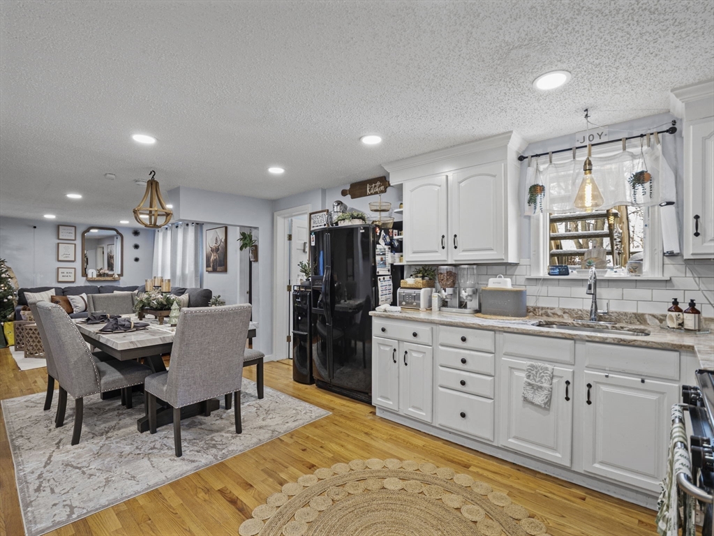 8 Clarks Court Lowell, MA 01852 - Photo 6 of 33 a large kitchen with kitchen island a dining table chairs stainless steel appliances and cabinets