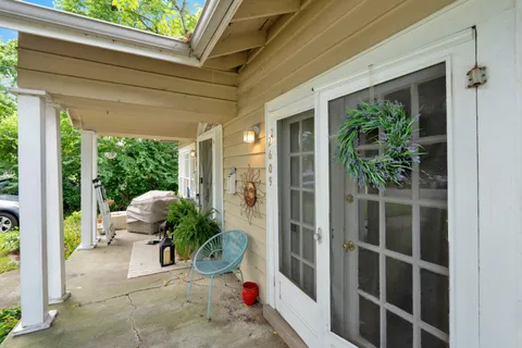 a view of a porch with chairs and potted plants